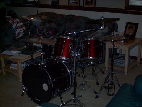 1986 Ford Bronco - A drum kit is set up indoors, with a couch and side table visible in the background.