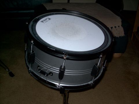 1986 Ford Bronco - A snare drum is shown on a stand, a white drum head and a silver body.