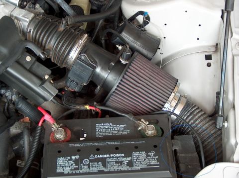 1998 Ford Taurus - Close-up view of the engine compartment, focusing on the air intake system and the vehicle's battery.