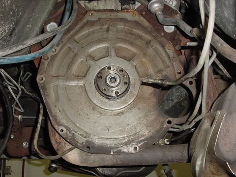 1995 Ford Bronco - Close-up view of a transmission bell housing, showing mechanical components and associated plumbing.