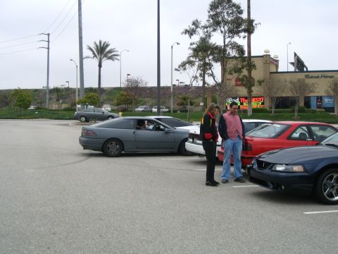 1995 Ford Probe - A 1995 Ford Probe is parked in a lot, with people and other vehicles present.