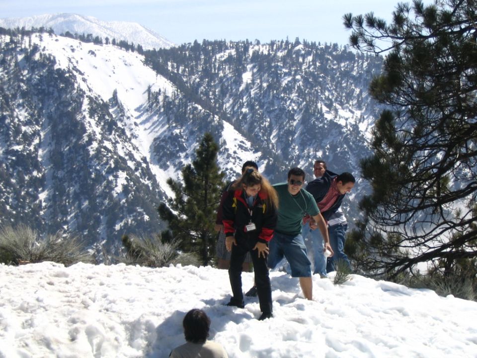 Group of people in snow-covered mountains, some are posing for a photo