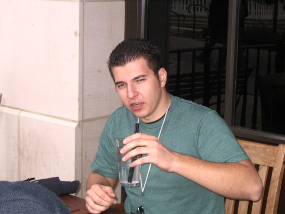 Man drinking from a glass with a straw