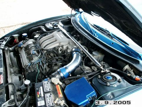 1993 Mazda MX-6 - Close-up view of a car's engine bay, showing the V6 engine and associated components.
