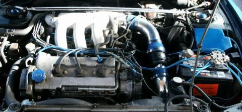 1993 Mazda MX-6 - The engine bay of a car is shown with various components and blue hoses.