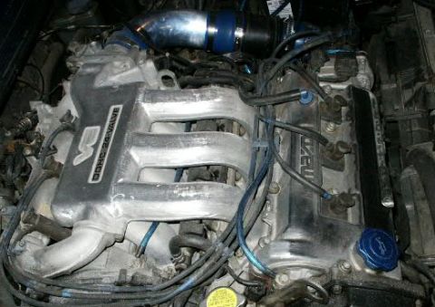 1993 Mazda MX-6 - Close-up of a Mazda engine, likely from a 1993 model, showing the valve cover and intake manifold.