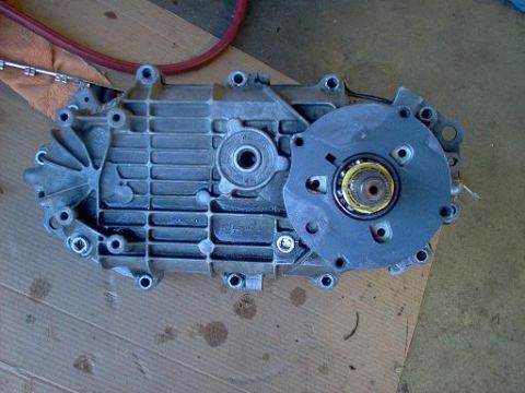 1988 Ford Bronco - A disassembled transfer case sits on a wooden surface, ready for rebuild.