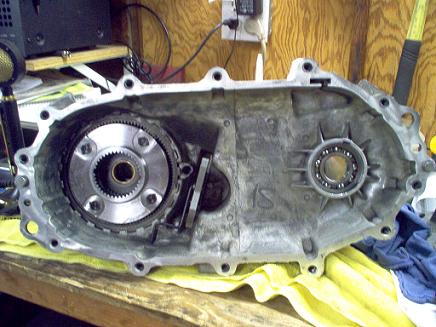 1988 Ford Bronco - Disassembled transfer case housing with internal gears and bearing visible.