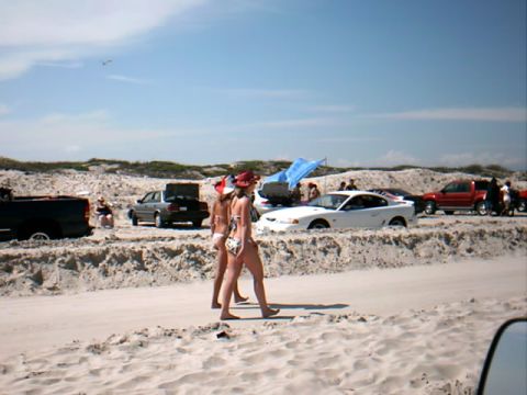 1978 Ford Bronco - Several vehicles are parked on a sandy beach with people walking near the water.