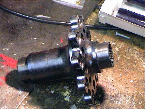 1979 Ford Bronco - A differential housing part is shown on a workbench, with visible text on its side.