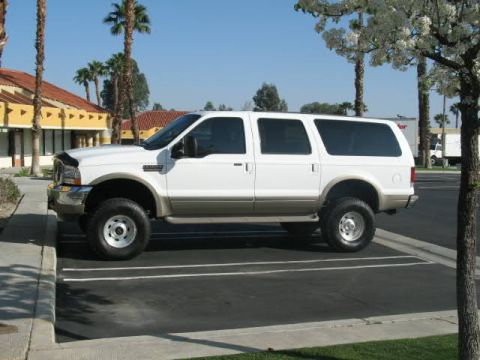 2002 Ford Excursion - This white Ford Excursion SUV is parked in a lot, showing its side profile and tan lower body trim.