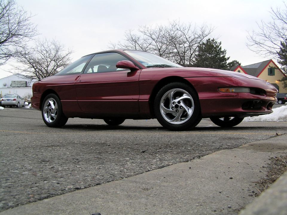 Maroon Ford Probe coupe with chrome wheels, low-angle side view in a winter parking lot
