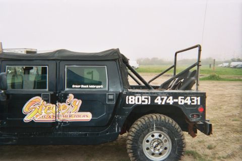 1990 Ford Bronco - Close side view of a black soft-top Hummer marked with a 'Steve's' tour decal and the phone number (805) 474-6431.