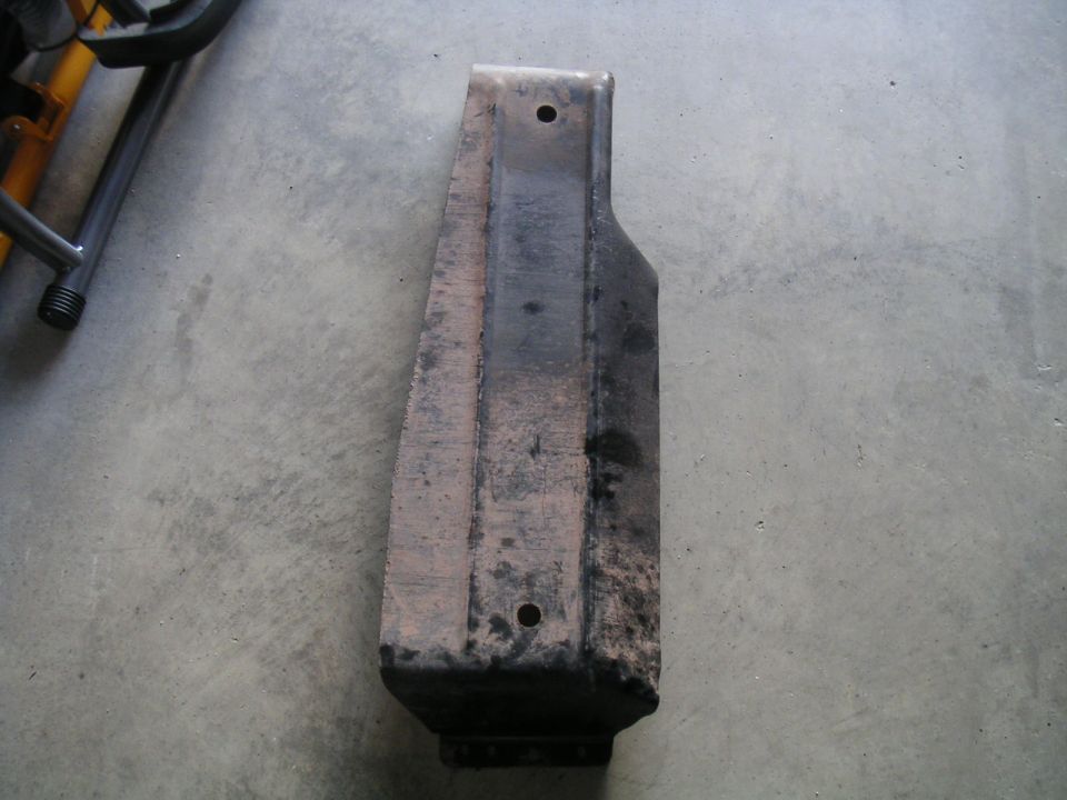 Metal part on concrete floor with Supermotors.net watermark