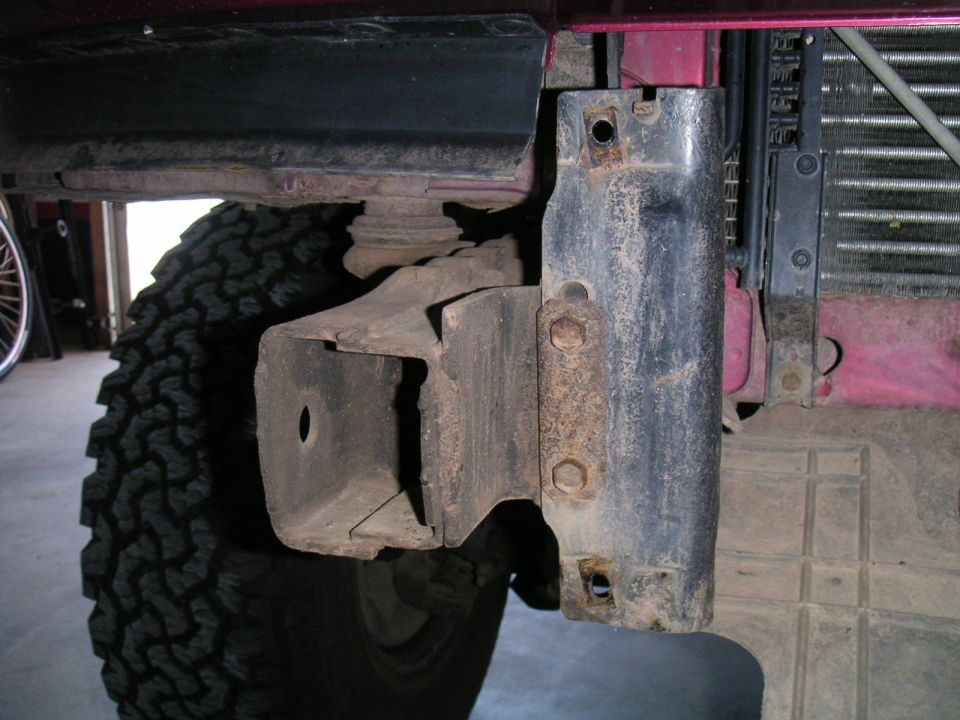 Close-up of a vehicle's frame, tire, and part of the radiator