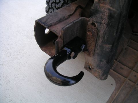 1994 Ford Bronco - Close-up of a tow hook mounted on a vehicle's frame, with a tire in the background.