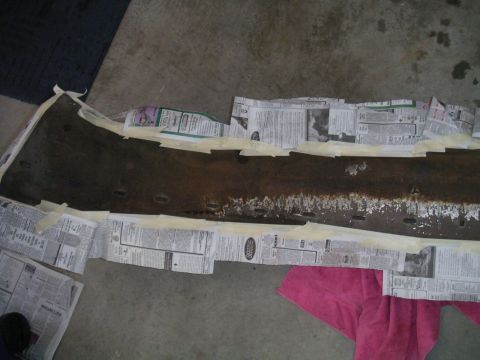 1994 Ford Bronco - A car bumper is masked with newspaper and tape, likely for repair or painting.