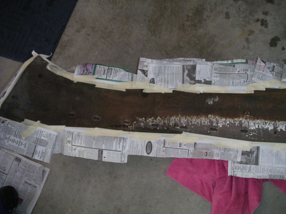 Car bumper covered in newspaper and tape, ready for work