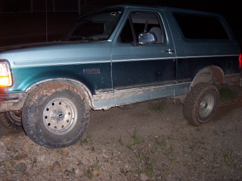 1996 Ford Bronco - This two-tone Ford Bronco is shown off-road with mud on its tires and body.