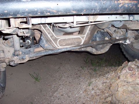 1996 Ford Bronco - The undercarriage of an off-road vehicle is shown, with focus on the suspension and steering systems.
