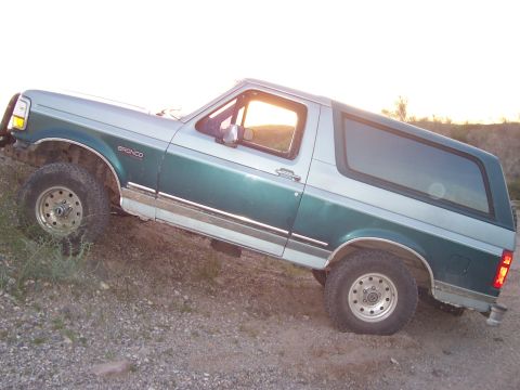 1996 Ford Bronco - This 1996 Ford Bronco is shown in a two-tone green and silver paint scheme, angled on a dirt incline.