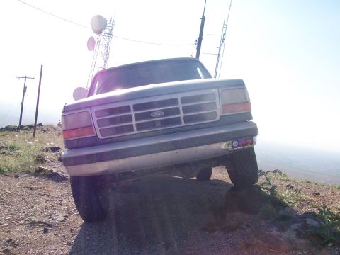 1996 Ford Bronco - A gray Ford truck is angled on a rocky incline with a radio tower in the background.