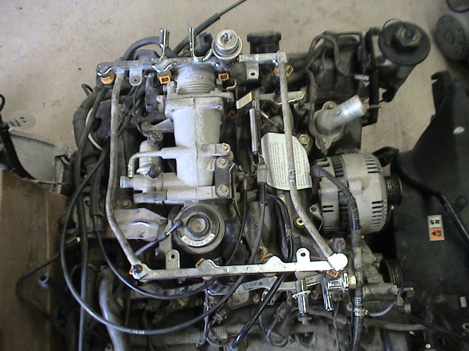 Removed engine showing fuel rails, injectors, and alternator