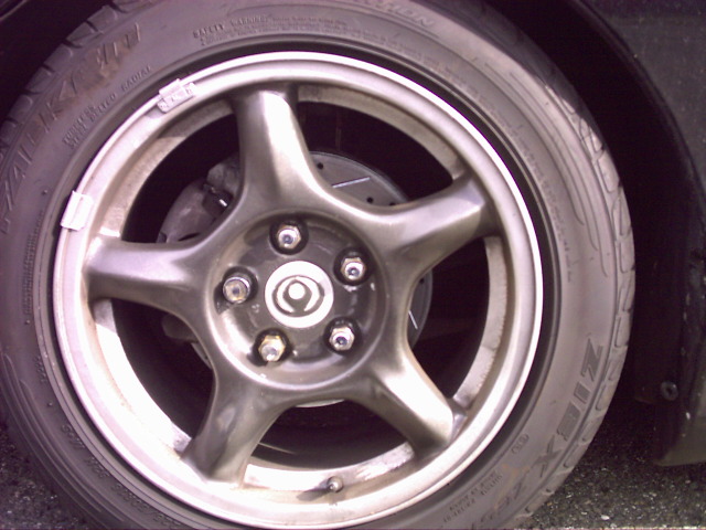 Close-up of gunmetal 5-spoke alloy wheel with Falken Ziex tire and slotted brake rotor visible