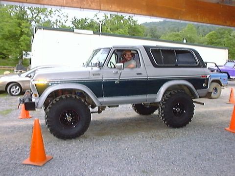 1978 Ford Bronco - A lifted 1978 Ford Bronco is parked outside, with a driver visible inside.
