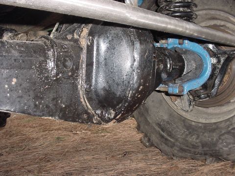 1969 Ford Bronco - Rear axle differential housing with blue U-bolt clamps and a tire.