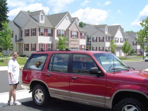 1992 Ford Explorer - A red 1992 Ford Explorer is parked in front of a row of townhouses on a sunny day.