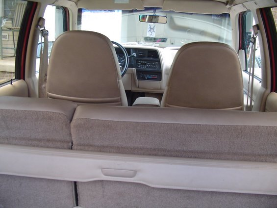 Tan cloth interior of a two-door SUV seen from the cargo area over the folded rear seat