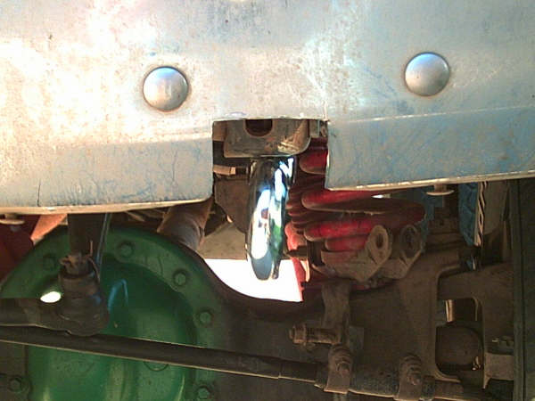 Underside view of front suspension with red coil spring, green-painted differential, and chrome shock
