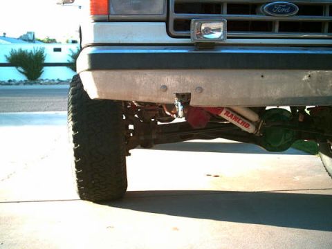 1988 Ford Bronco - Close-up of the front suspension and tire of a 1988 Ford Bronco, Ranen shocks and a Ford grille.