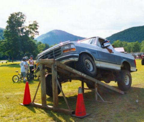 1995 Ford Bronco - Ford F-Series truck is positioned on a ramp during an outdoor event.