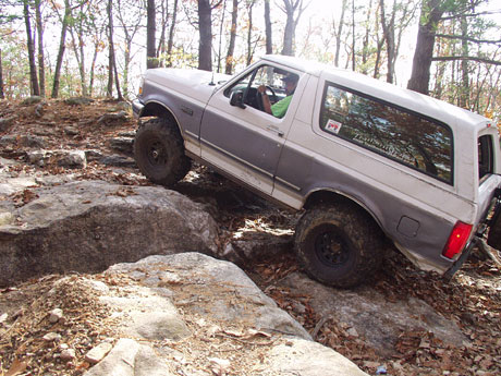 1995 Ford Bronco - A 1995 Ford Bronco navigates a rocky trail, demonstrating its off-road capabilities.