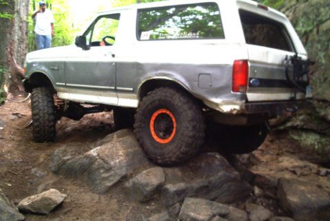1995 Ford Bronco - This 1995 Ford Bronco is shown tackling a challenging off-road course with large rocks.