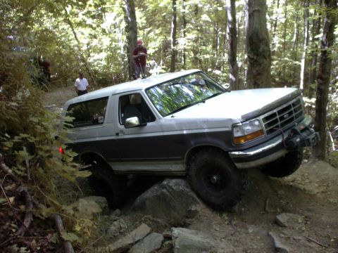 1995 Ford Bronco - This 1995 Ford Bronco is shown tackling a challenging off-road course with rocky terrain.