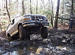 1995 Ford Bronco - This 1995 Ford Bronco tackles a challenging off-road course, demonstrating its capability in rough terrain.