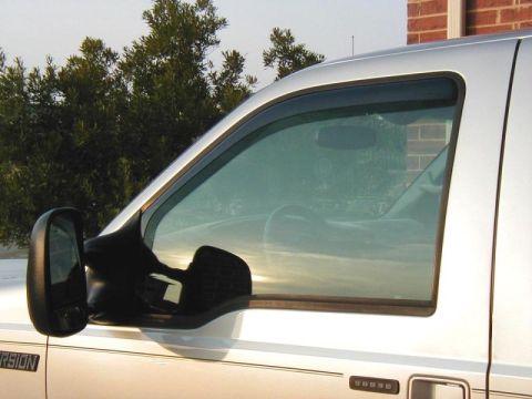 2002 Ford Excursion - Close-up of the side mirror and window of a 2002 Ford Excursion, showing the vehicle's exterior details.
