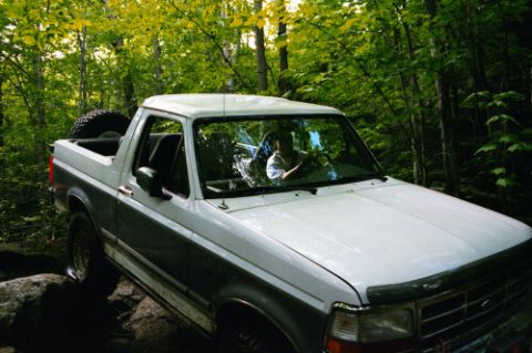 1995 Ford Bronco - This 1995 Ford Bronco navigates a challenging path through a dense forest.