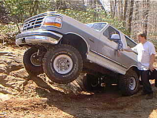 1995 Ford Bronco - A 1995 Ford Bronco navigates a rocky off-road obstacle.