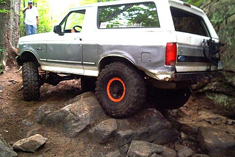 1995 Ford Bronco - This modified Ford Bronco navigates a challenging rocky terrain, its off-road capabilities.
