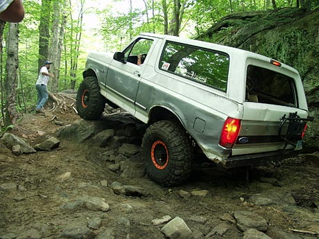 1995 Ford Bronco - This 1995 Ford Bronco is navigating a challenging off-road course with steep inclines and large boulders.