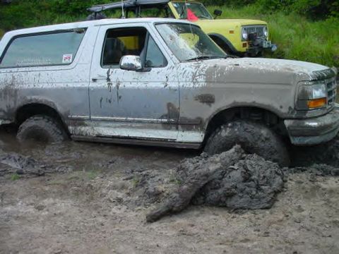 1995 Ford Bronco - This 1995 Ford Bronco is deep in the mud, with another vehicle visible in the background.