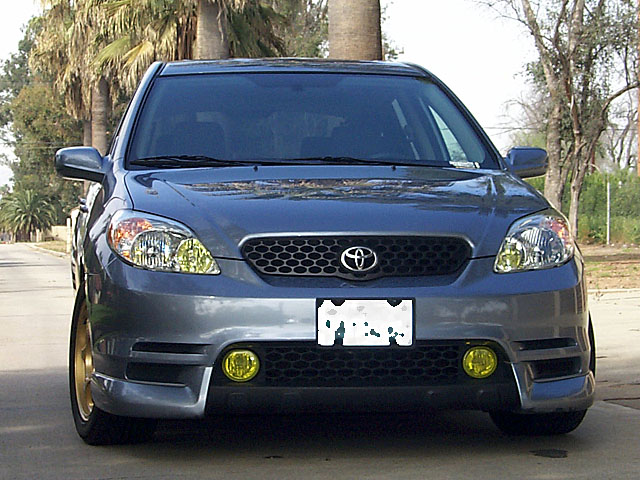 Front view of gray Toyota Matrix with yellow fog lights and gold wheels