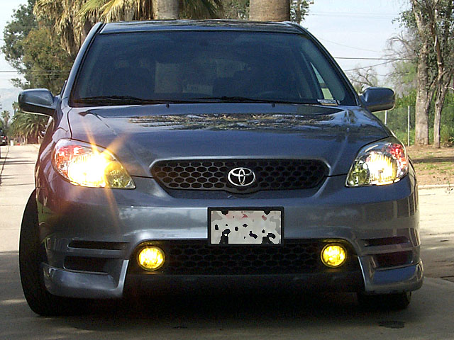 Gray Toyota Matrix front view with headlights and yellow fog lights on