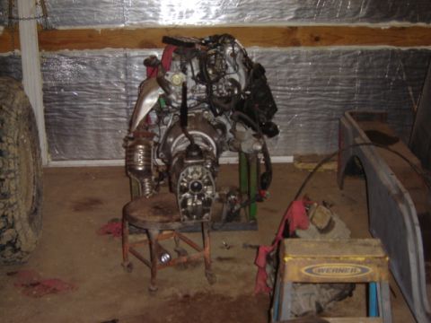 1992 Ford Bronco - An engine and transmission assembly is displayed on a stand in a workshop setting.