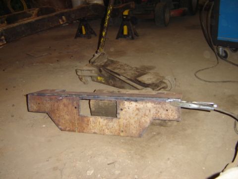 1992 Ford Bronco - A rusty metal part, possibly a frame component, is shown with welding equipment. A jack and jack stands are visible in the background.