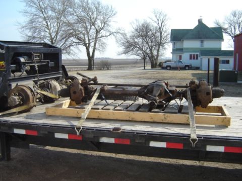1992 Ford Bronco - Two vehicle axles are secured on a trailer, ready for transport or installation.